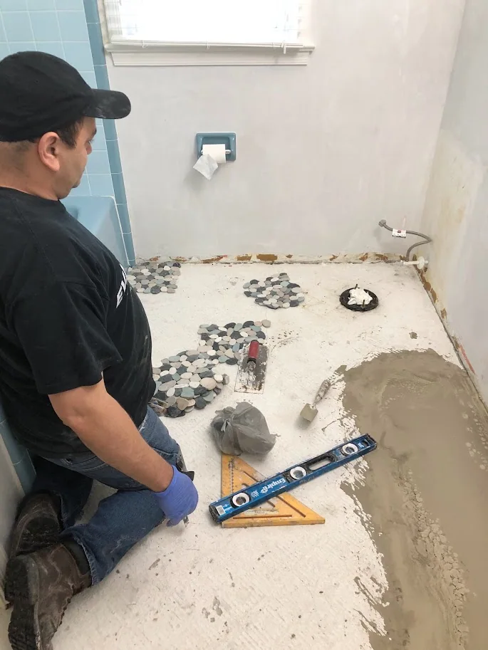 Profissional Victoria Home a preparar o pavimento e a instalar mosaico, com nível e ferramentas de precisão